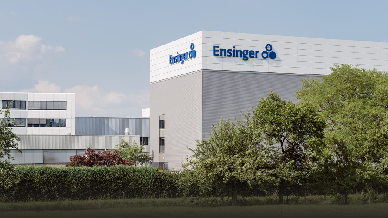 Ensinger headquarters in Nufringen with company logo and surrounding greenery.